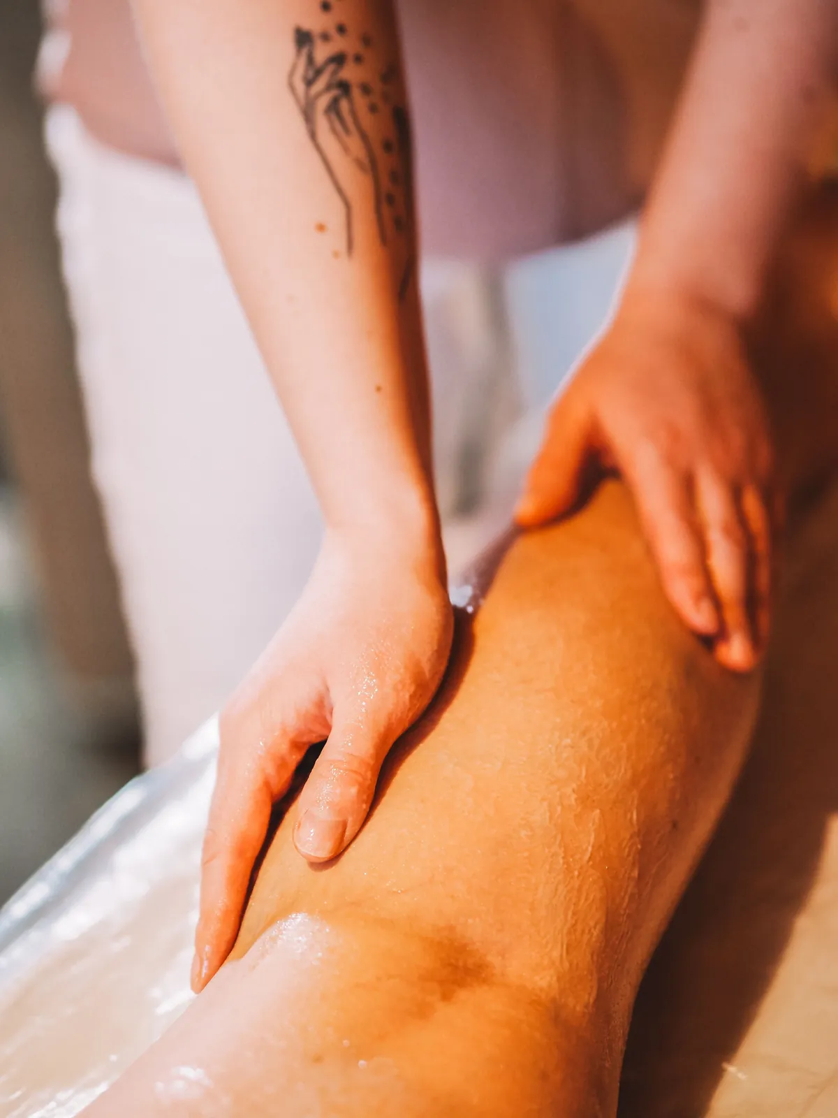 Therapist working a client’s thigh and knee during a sports massage in Salt Lake City