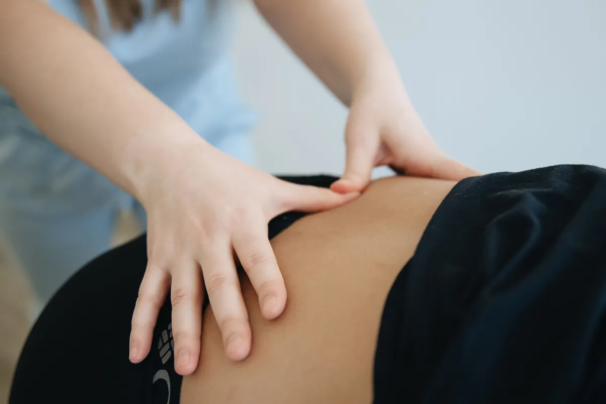 Therapeutic massage focused on a client’s lower back in a Salt Lake City clinic setting